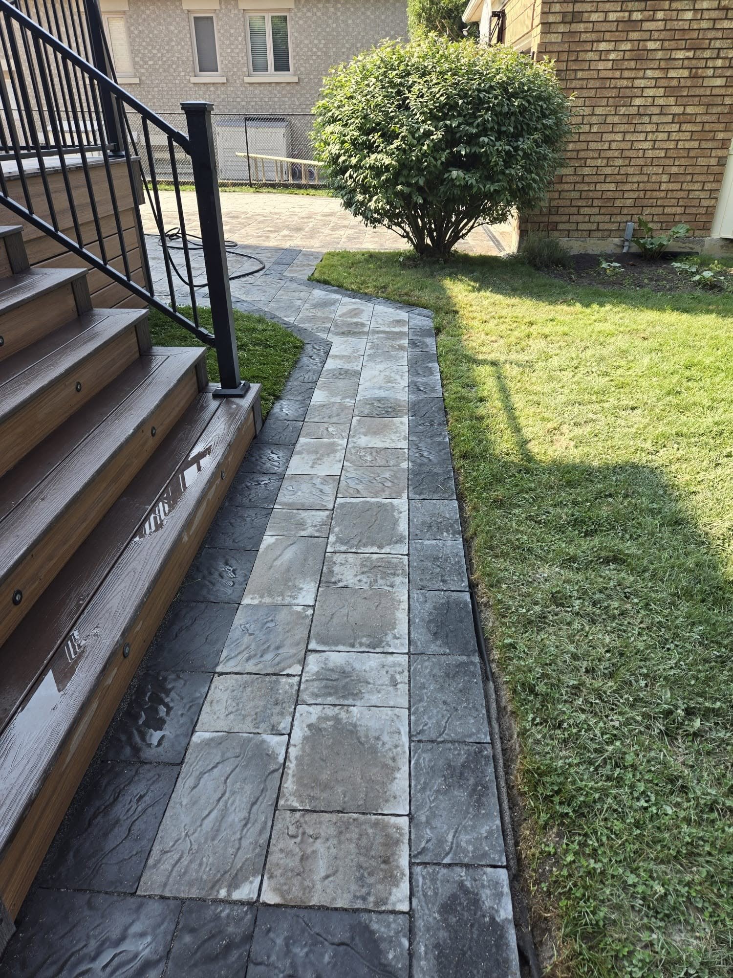 Stone paver walkway beside a manicured lawn